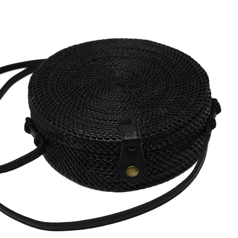 Poppy and Sage black circle rattan straw shoulder bag handmade in Bali. Flat lay photo.